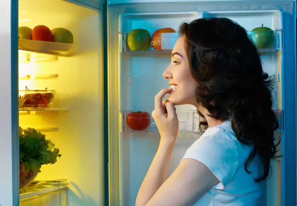 meitene skatās ledusskapī straujas svara zaudēšanas laikā